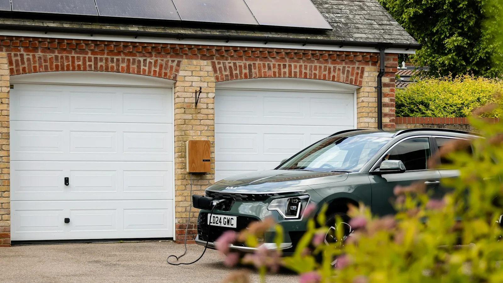 A British brick property with roof solar panels and driveway EV charging